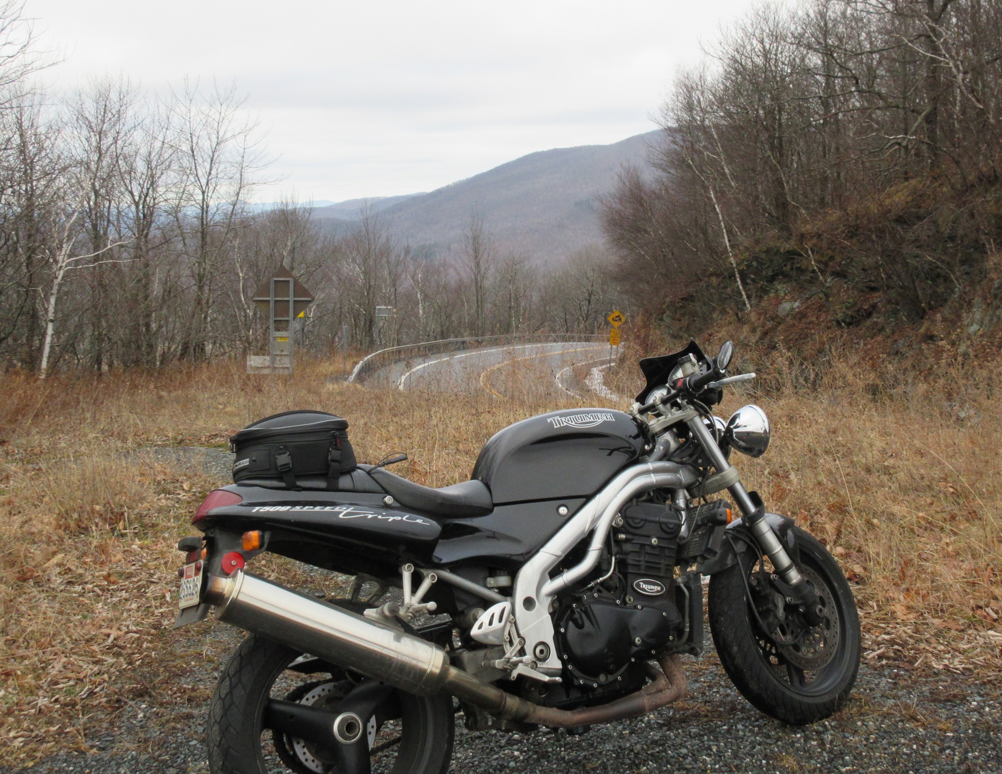 Speed Triple with Dunlop Mutant tires parked on a mountain overlook under gray winter sky