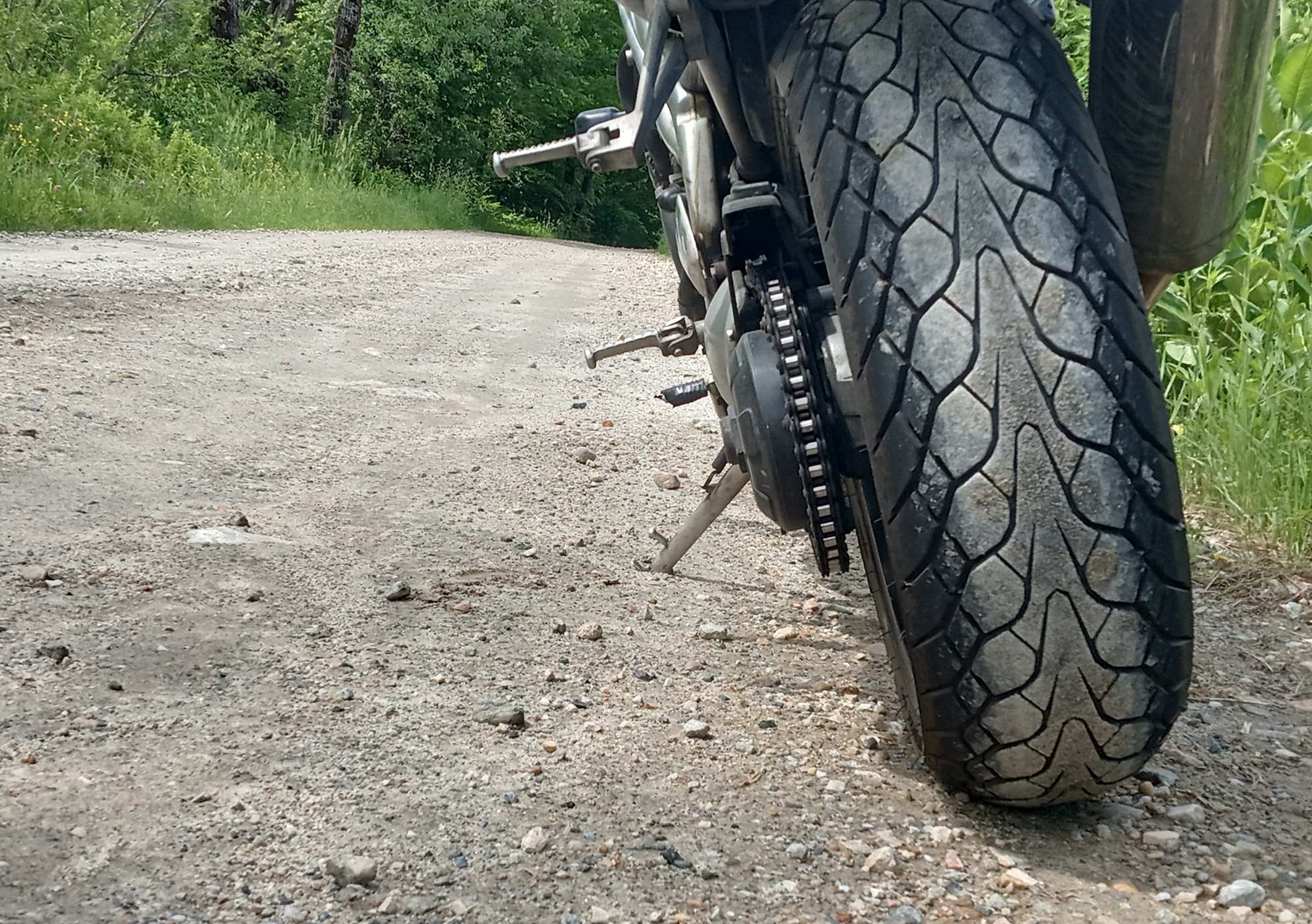 closeup of rear Dunlop Mutant tire on my Speed Triple parked on a dirt country road