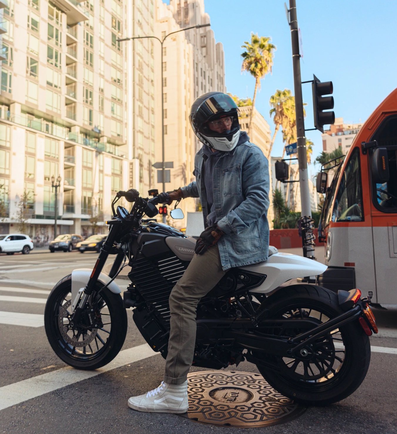 rider on a LiveWire S2 at a city stop light looking back over his shoulder