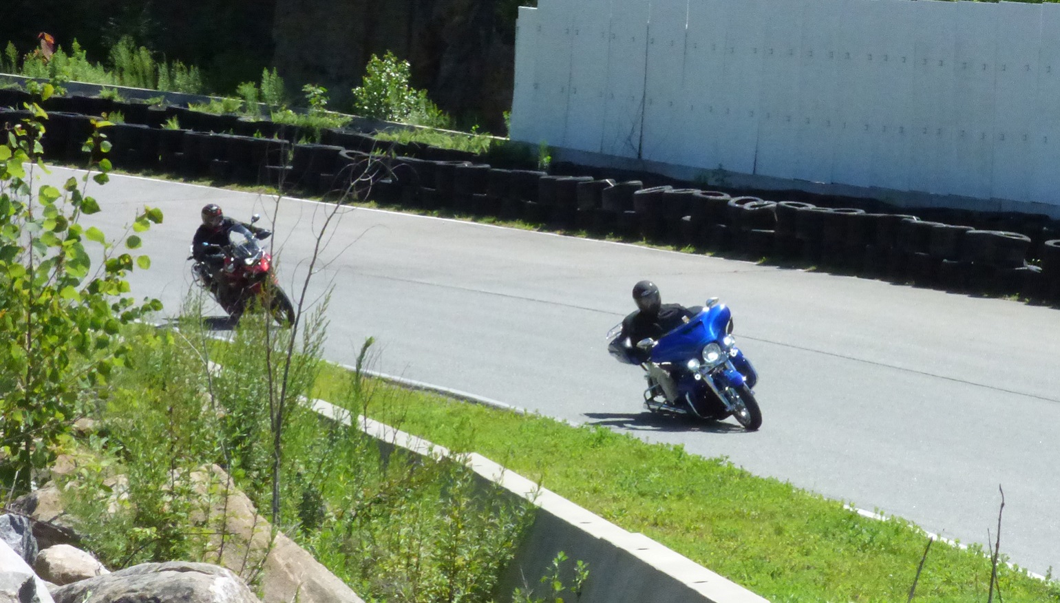 a Harley-Davidson touring motorcycle and an adventure motorcycle on the track