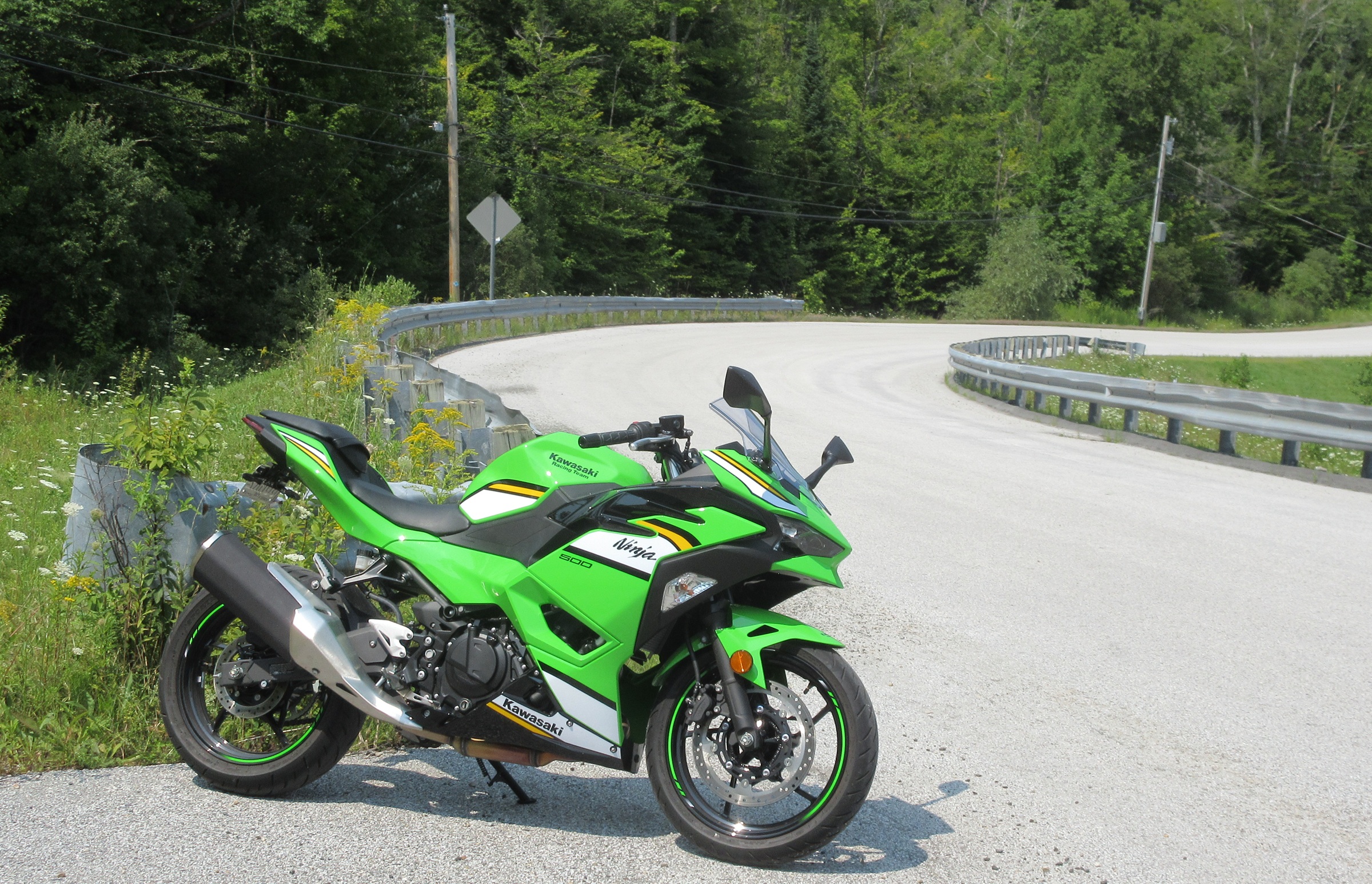 green Ninja 500 parked along a curve on a country road in the sun