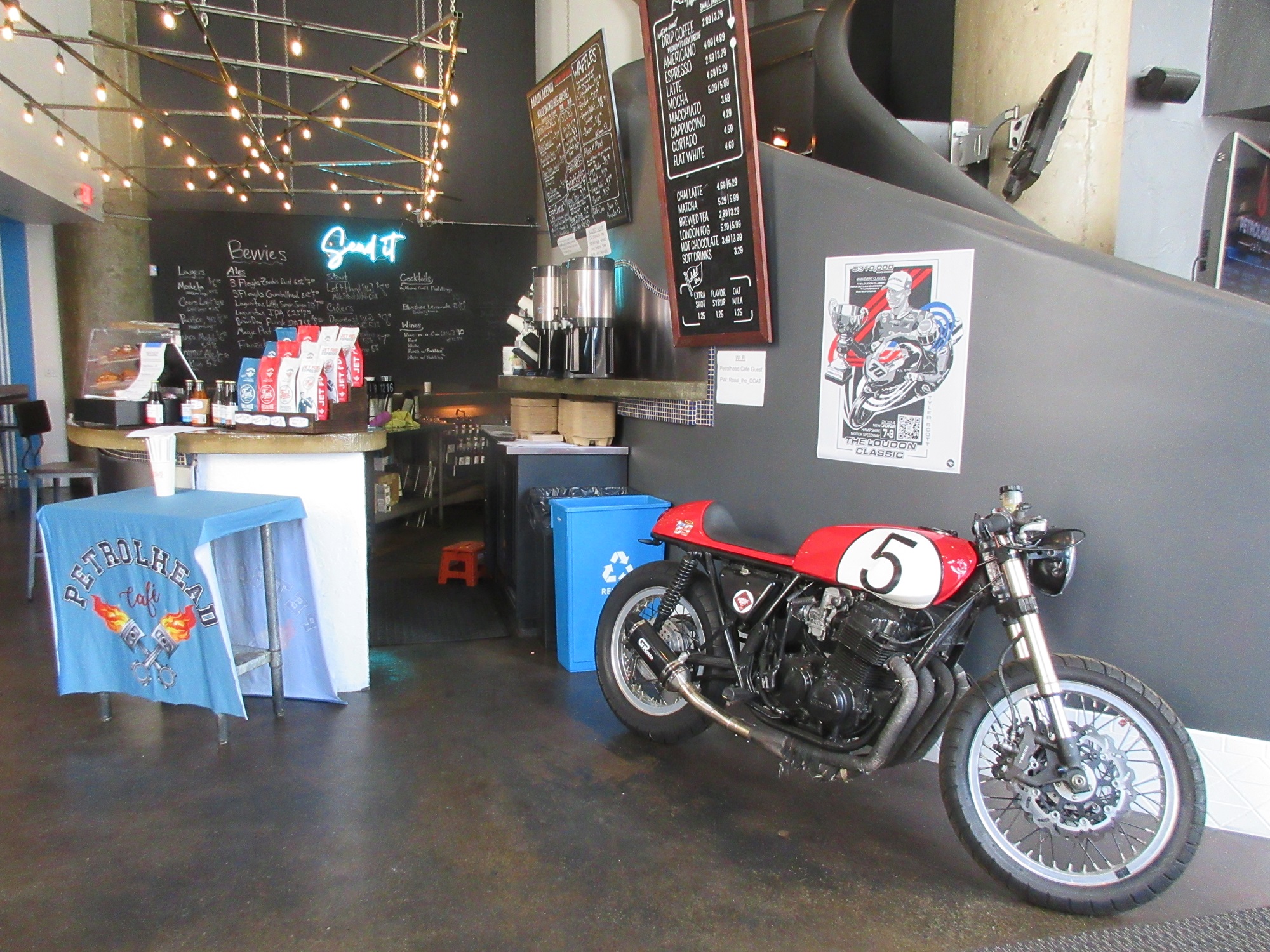 interior view of Petrolhead with a custom motorcycle parked by the bar and a menu on the chalkboard