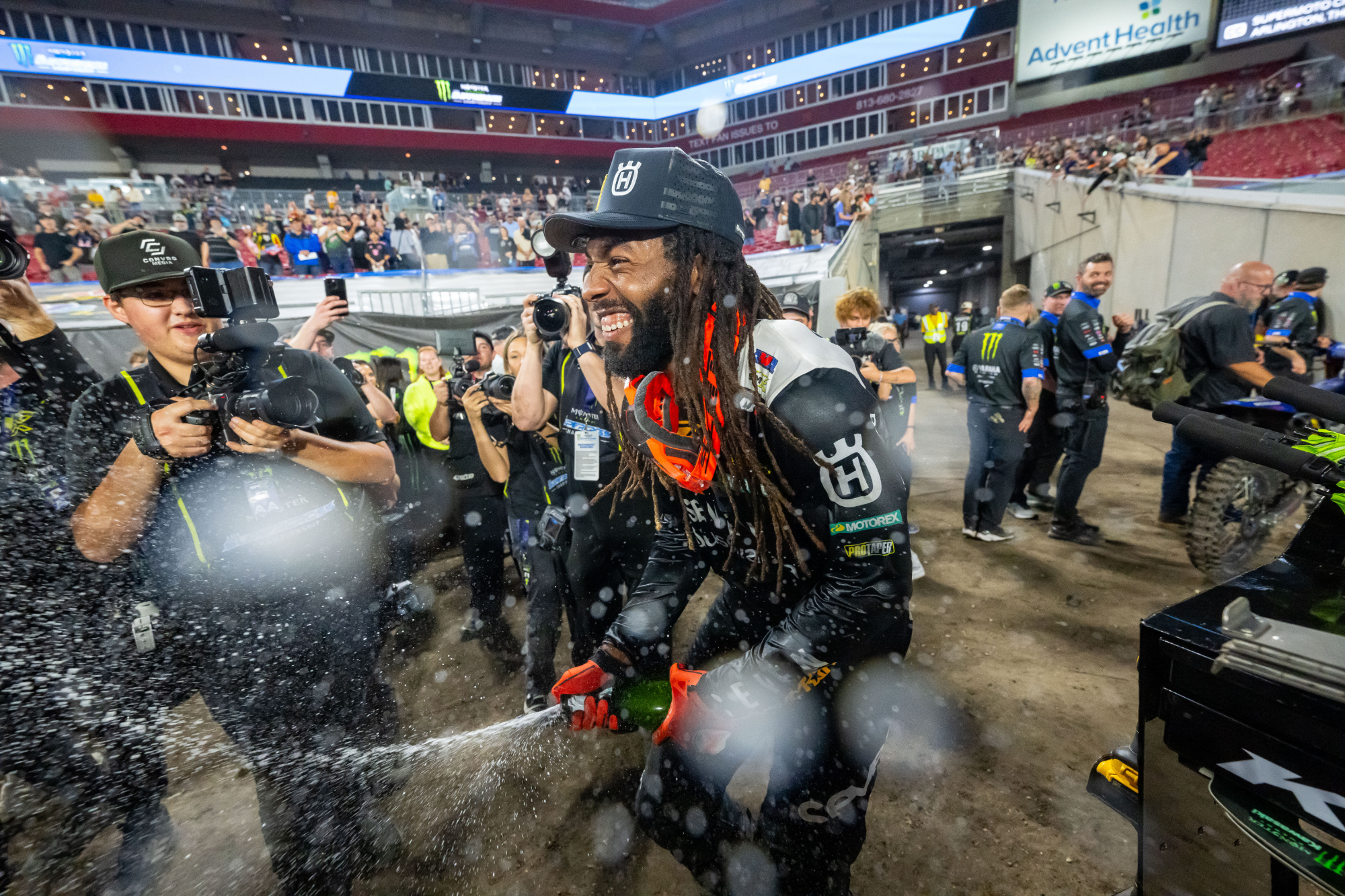 Malcolm Stewart smiling and spraying champagne in front of photographers after winning the Tampa Supercross race