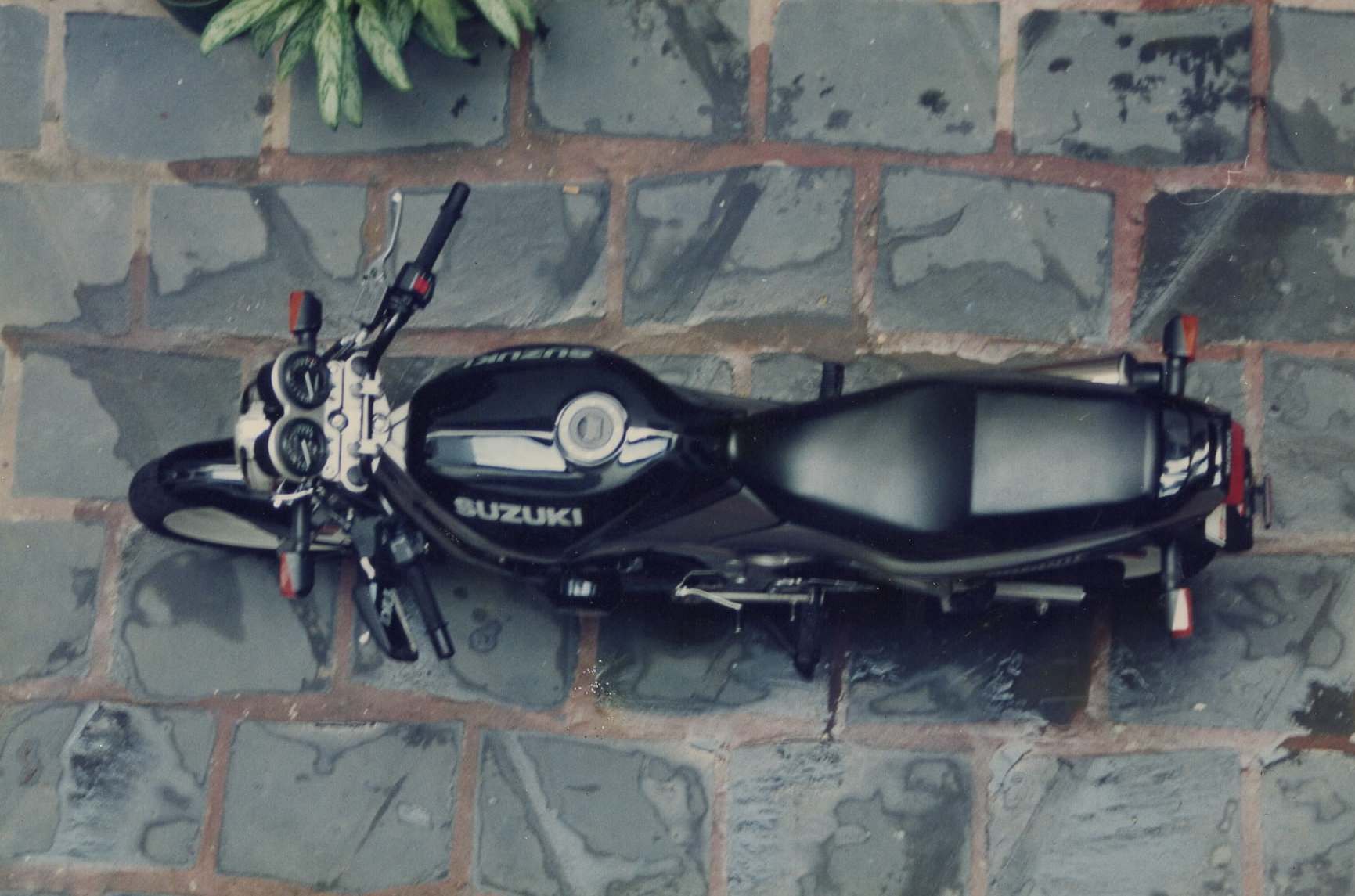 overhead view of a black Suzuki GS500E on blue tiles